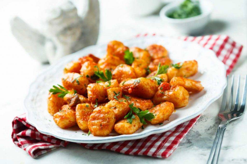 Gli gnocchi con zafferano salsiccia e scaglie di grana