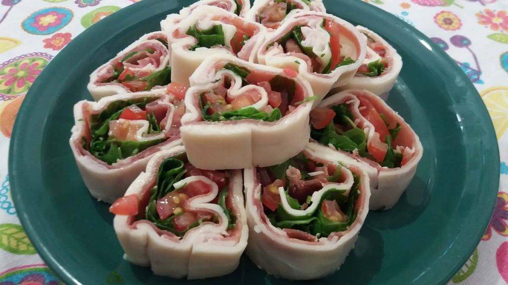 Rotolo di formaggio farcito, prosciutto, rucola e pomodorini