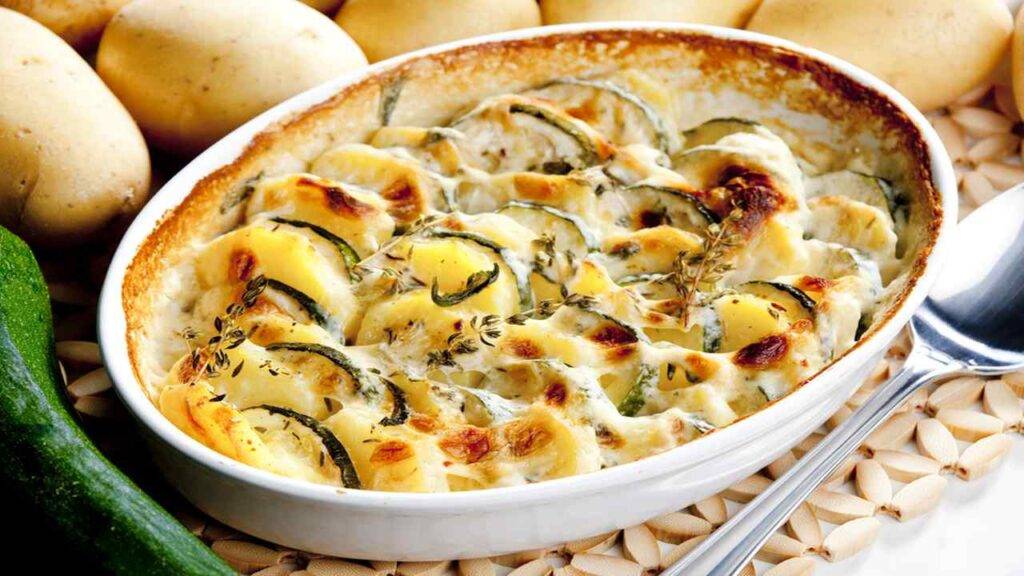 Patate zucchine e mozzarella | Un contorno filante al forno