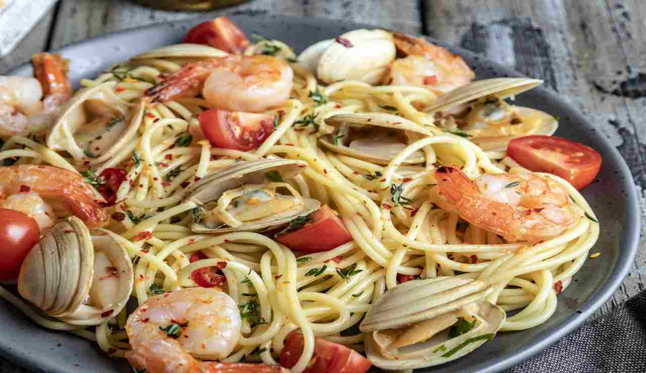 Spaghetti macchiati al peperoncino con vongole e gamberetti AdobeStock