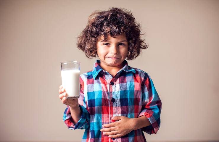 Bimbo con bicchiere di latte in mano
