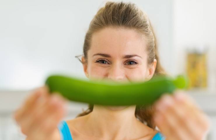 Una donna regge una zucchina