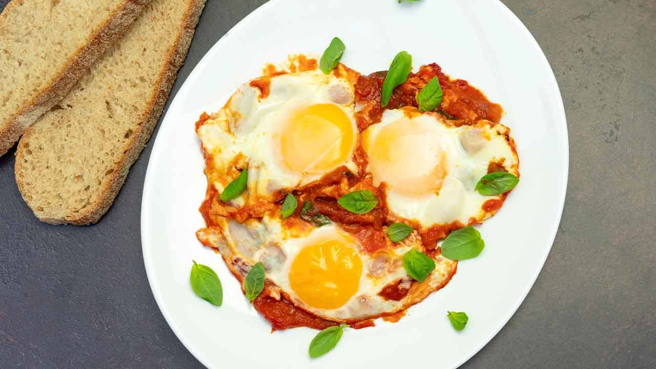 Uova con polpa di pomodoro e formaggio grattugiato