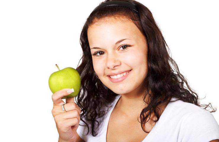 Una ragazza regge una mela