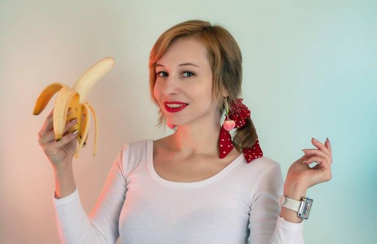 Una donna mentre mangia una banana