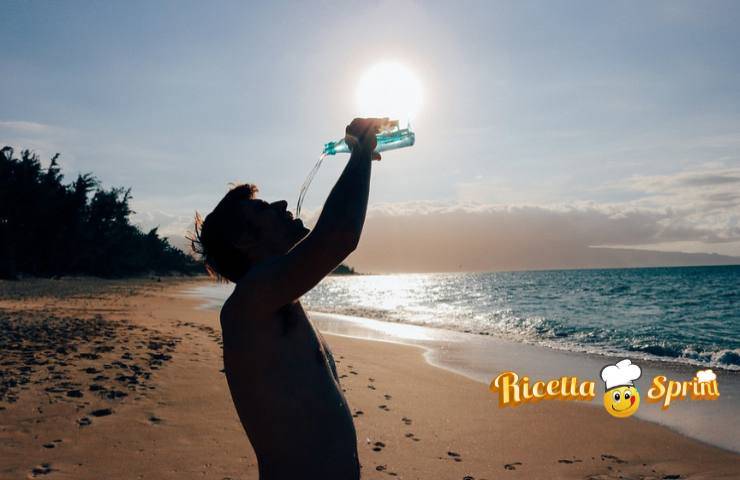 Un uomo beve al caldo in spiaggia