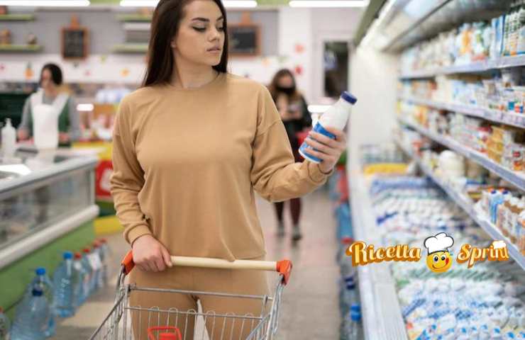 Una donna controlla il latte al supermercato