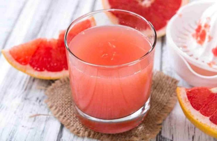 Una bevanda al pompelmo rosa in un bicchiere