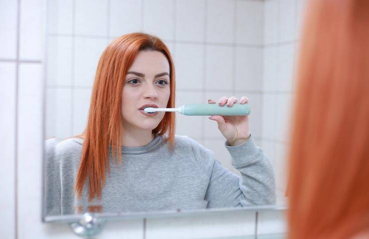 Una ragazza nell'atto di lavarsi i denti