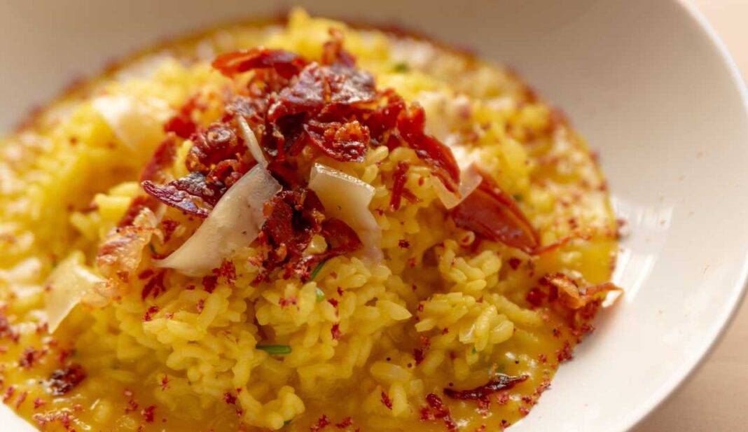 Risotto cremoso allo zafferano con parmigiano e speck croccante, un