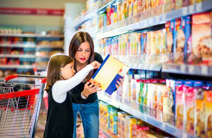 Una donna ed una bimba controllano un prodotto al supermercato