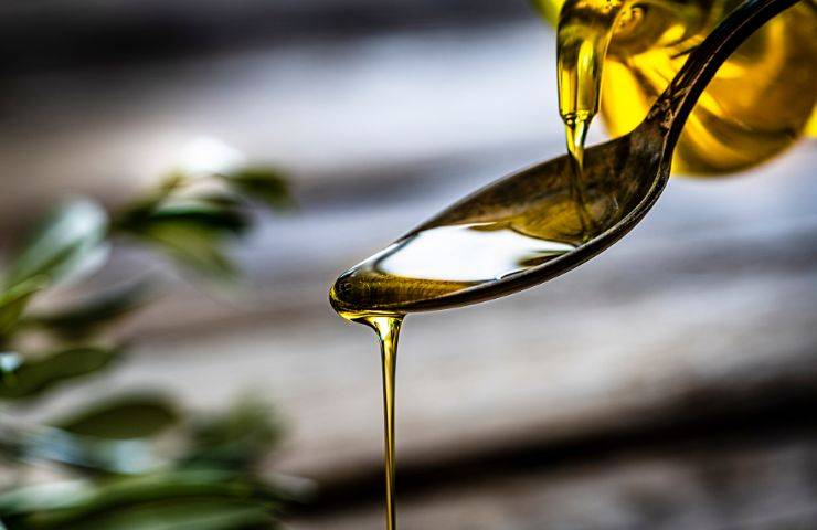 Dell'olio extravergine d'oliva versato su un cucchiaio