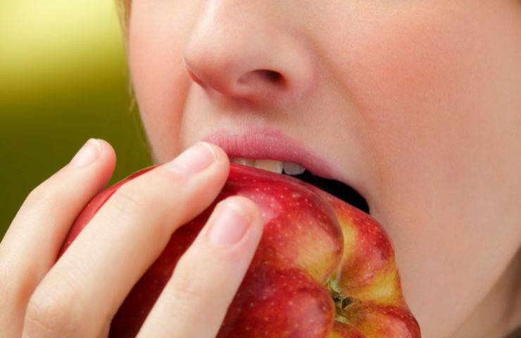 Una donna che mangia una mela