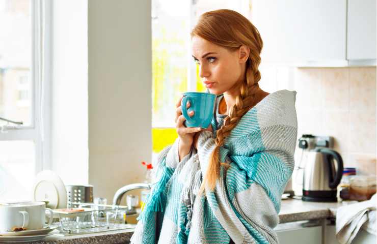 Una donna mentre beve del tè in cucina Ricettasprint.it 08122022