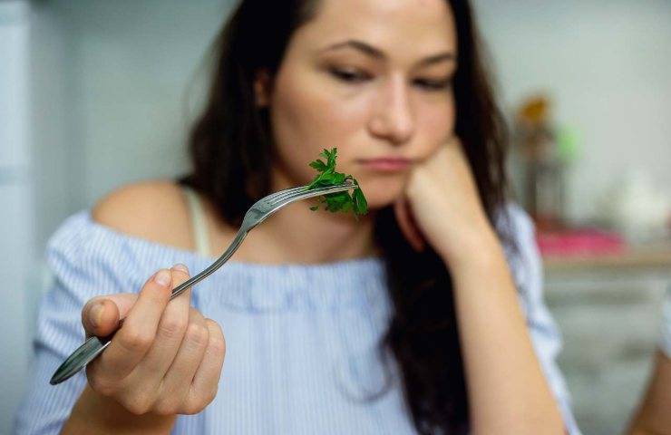 Una donna mentre mangia verdure