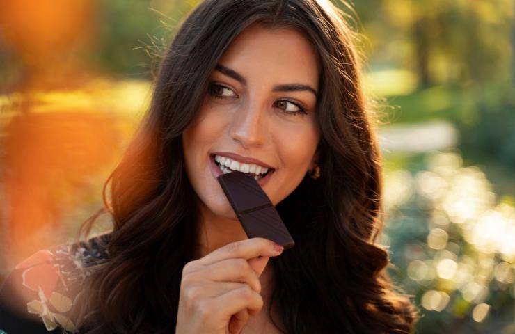 Una donna mangia della cioccolata fondente