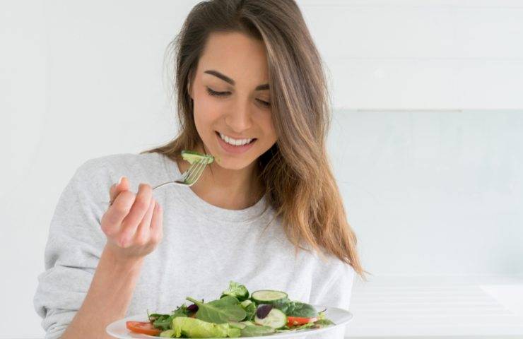 Una ragazza mentre mangia delle verdure