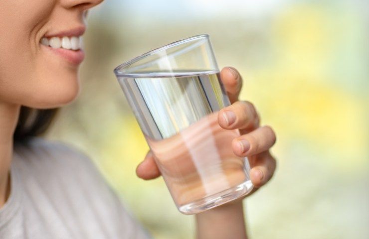 Una donna che beve un bicchiere d'acqua