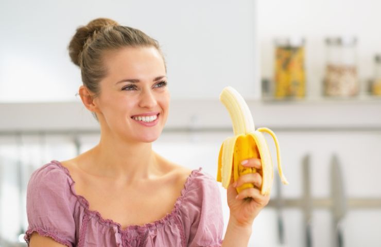 Una donna mentre mangia una banana