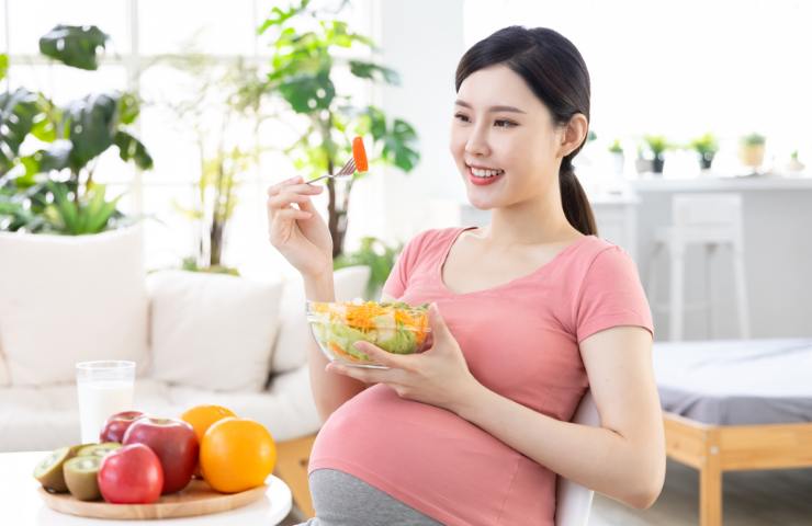 Una donna orientale incinta mentre mangia