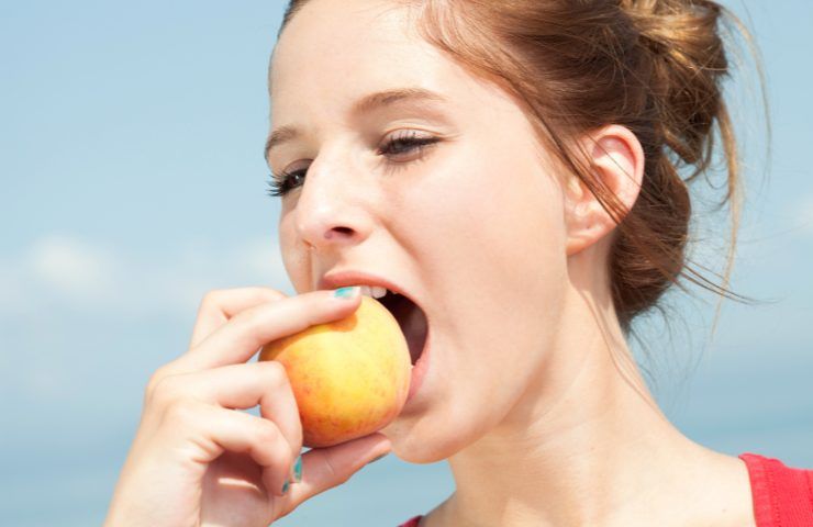 Una ragazza che mangia una mela