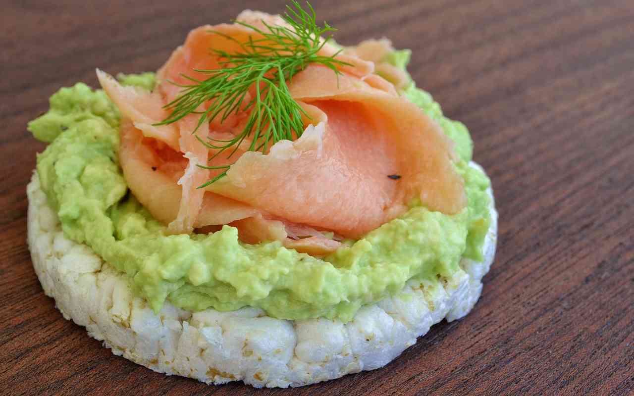 Trasforma le odiose gallette di riso, in un aperitivo delizioso a base di avocado e salmone, ti stupiranno!  --- (Fonte immagine: https://www.ricettasprint.it/wp-content/uploads/2023/08/Gallette-di-riso-con-avocado-e-salmone-31082023-ricettasprint.jpg)