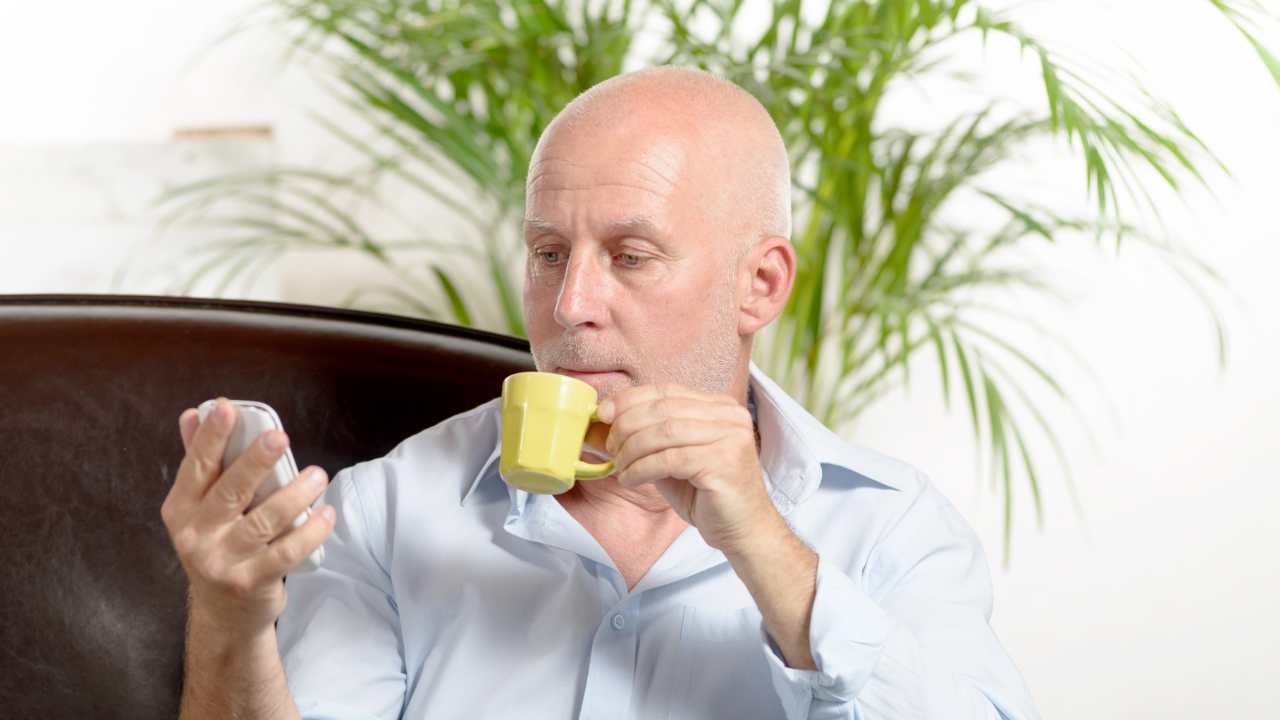 Uomo di mezza età beve caffè