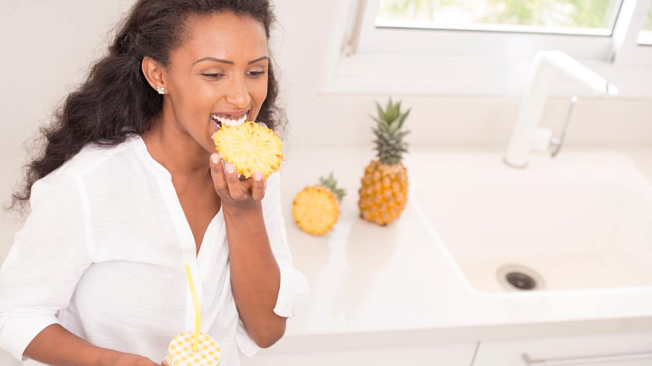 Donna che mangia ananas