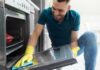 Uomo pulisce il vetro del forno