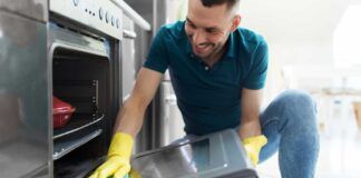 Uomo pulisce il vetro del forno
