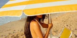 Donna in spiaggia sotto all'ombrellone