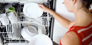 Una donna prende i piatti dalla lavastoviglie