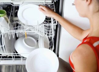 Una donna prende i piatti dalla lavastoviglie