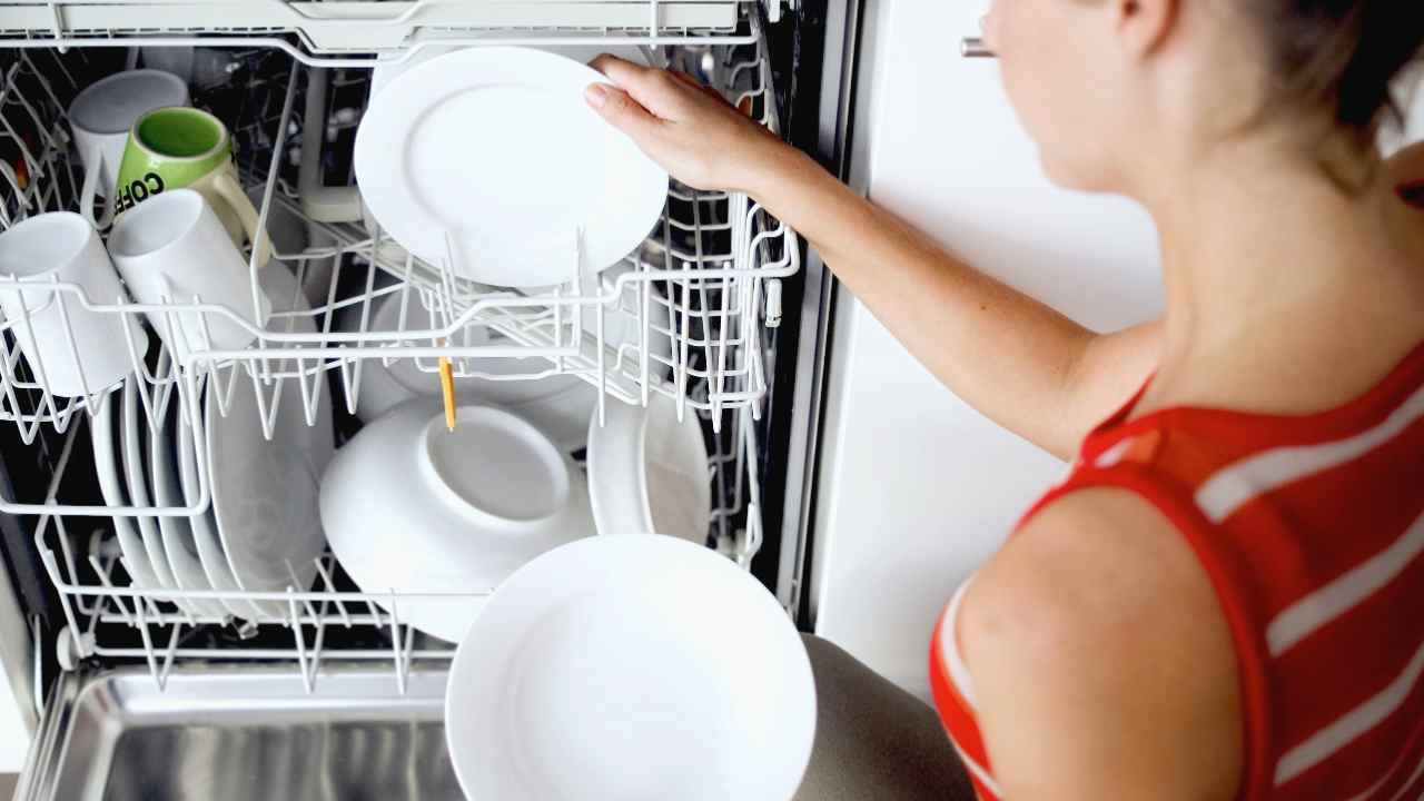 Una donna prende i piatti dalla lavastoviglie