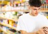Un giovane che controlla della passata di pomodoro al supermercato