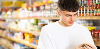 Un giovane che controlla della passata di pomodoro al supermercato