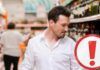 Uomo che controlla un liquore al supermercato
