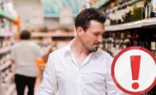 Uomo che controlla un liquore al supermercato