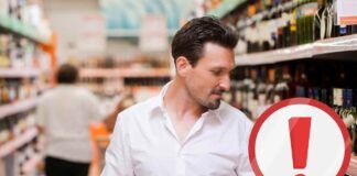 Uomo che controlla un liquore al supermercato