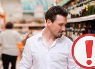 Uomo che controlla un liquore al supermercato