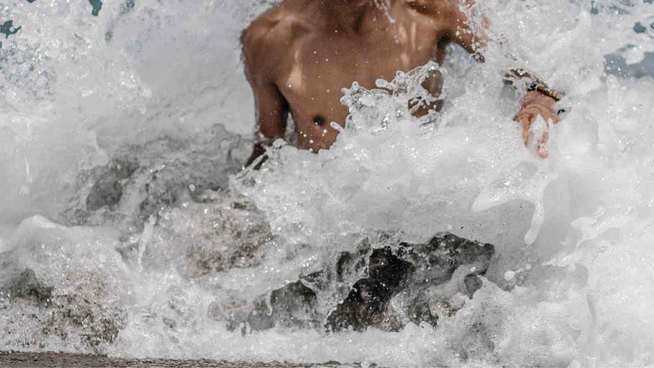 Giovane che fa il bagno a mare