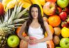 Una donna che soffre di colite su frutta che fa da sfondo