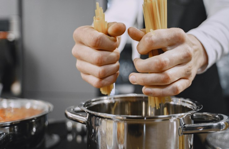 Spaghetti che stanno per essere messi in una pentola