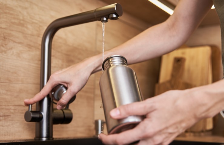 Acqua versata in una borraccia di metallo