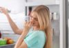 Una donna che sente della puzza dal frigo