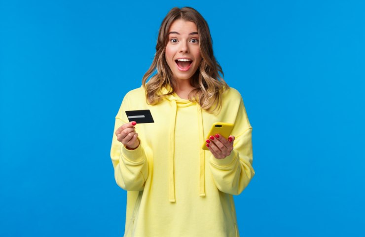 Una donna con una carta di credito ed uno smartphone
