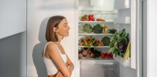 Una donna contenta davanti ad un frigorifero aperto