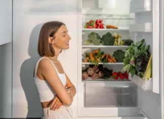 Una donna contenta davanti ad un frigorifero aperto