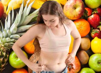 Una donna che tocca i suoi fianchi e della frutta come sfondo