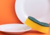 Dei piatti ed una spugnetta da cucina